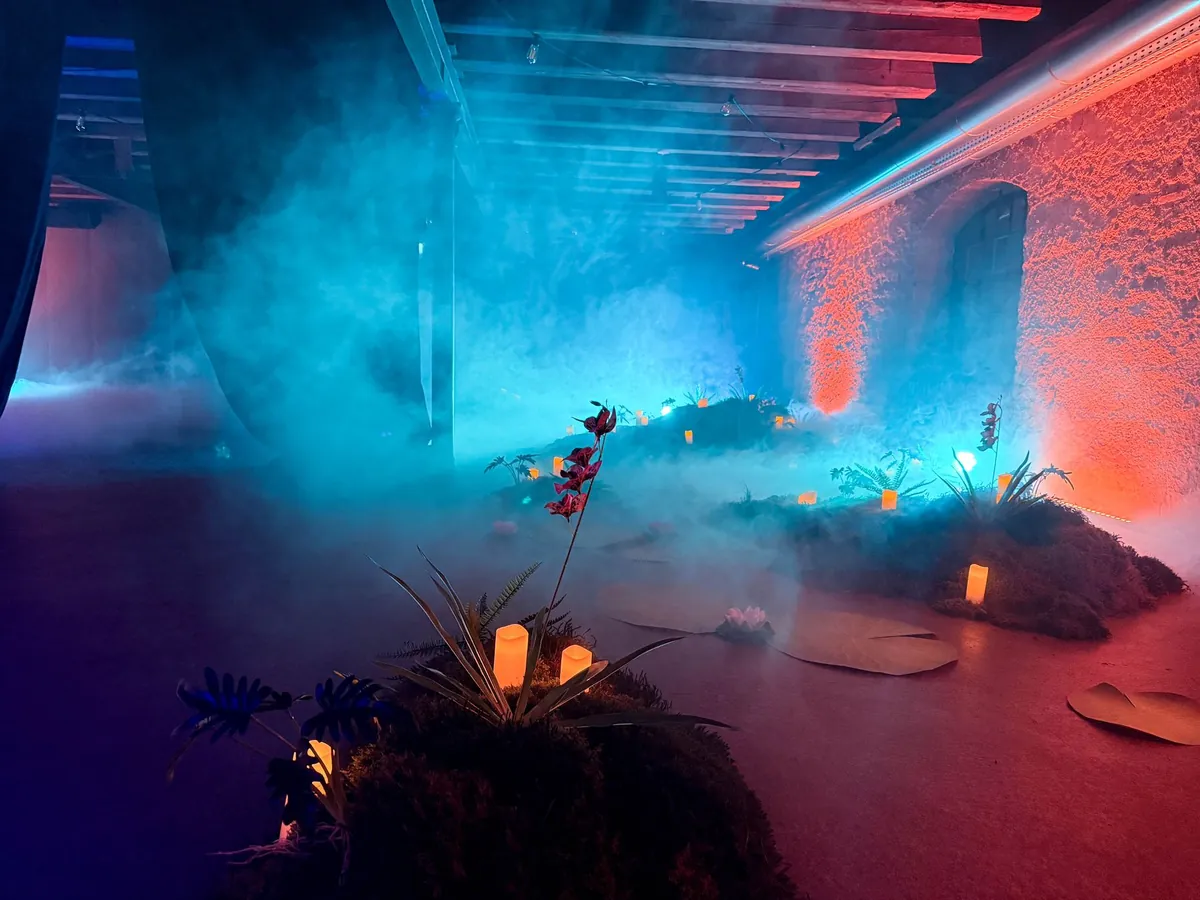 Türkiser Nebel über einer Moosinsel mit Orchidee und Kerzen
